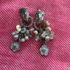 Silver drop earrings with dangling beads and a flower charm.